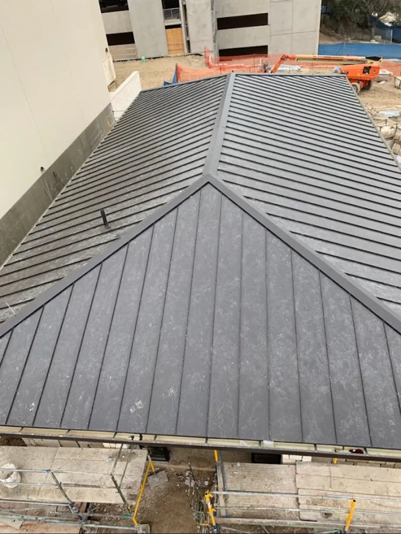Commercial metal roof construction with crane equipment in Muskogee